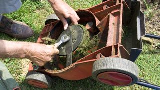 A lawn mower having it's blade removed with a wrench
