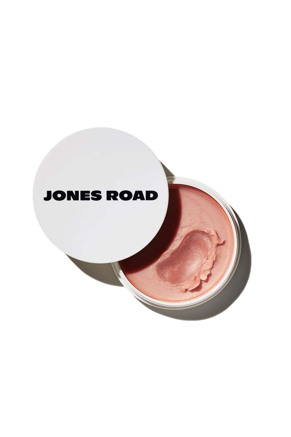 A Jones Road miracle balm set against a white background.