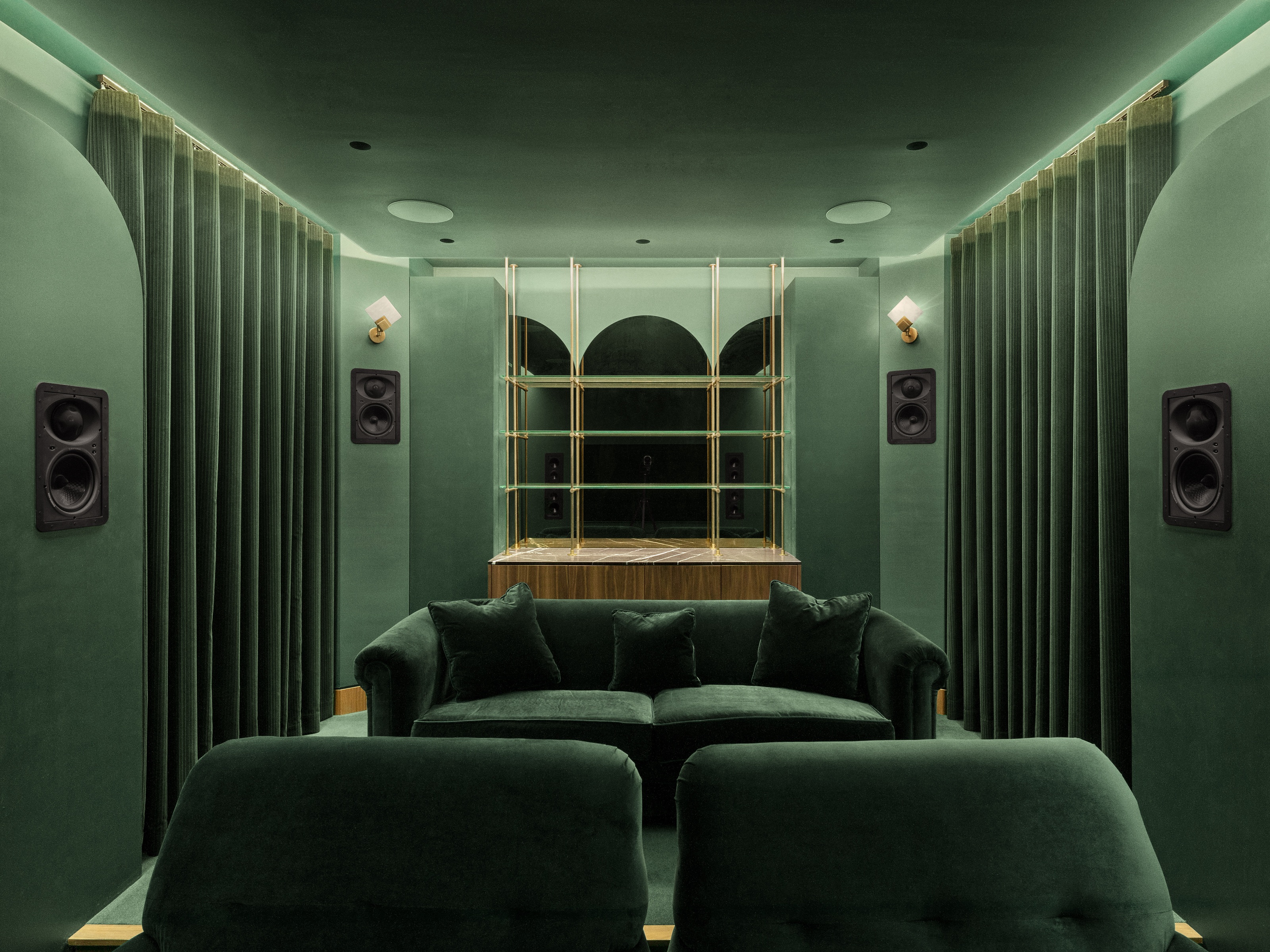 a green cinema room in an art deco with recessed lighting, green sofa and green curtains