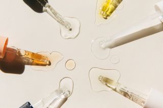 Pipettes containing skincare products on a beige background