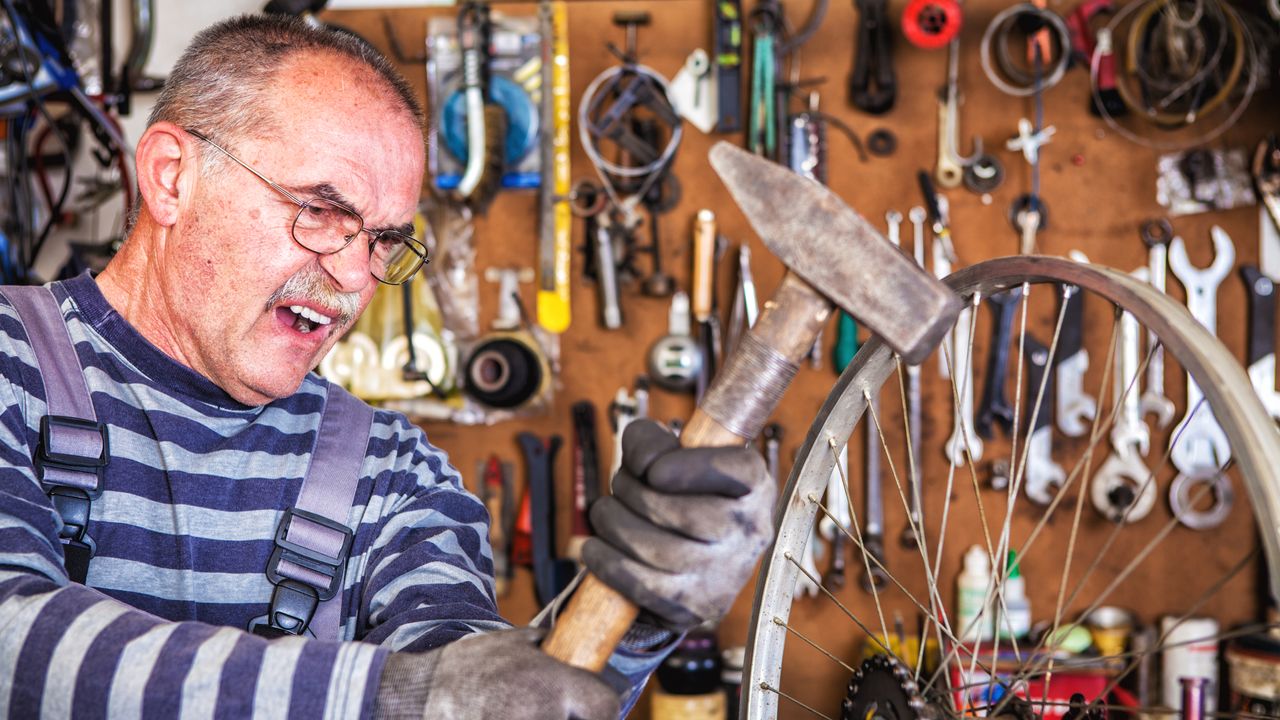 Mechanic takes a hammer to an old wheel