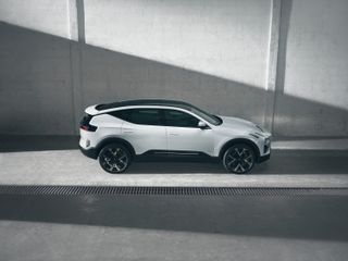 Side view of white car against concrete background