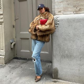 a woman in a furry jacket and jeans