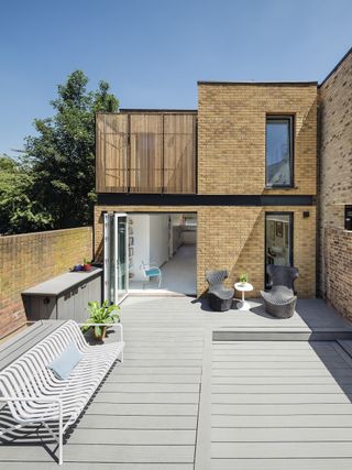 yellow brick self build with grey decking garden