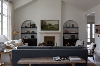 grey living room with arched recesses and a large cream sofa
