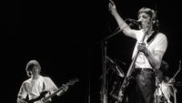 Eric Clapton (left) performs on stage as guest guitarist with Roger Waters (right) on Waters' 'Pros and Cons of Hitch Hiking' tour, Ahoy, Rotterdam, Netherlands, 19th June 1984