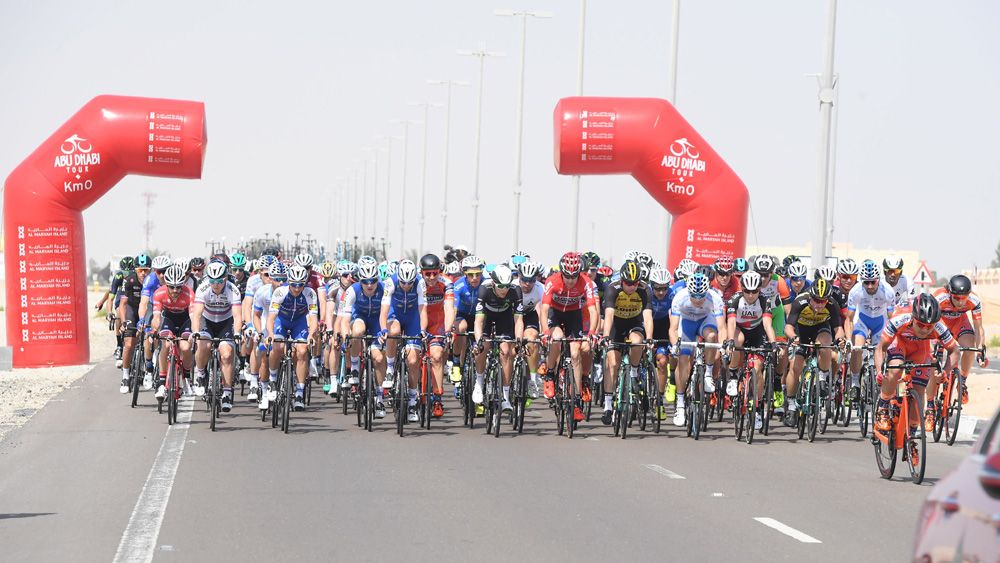 The riders pass the kilometre zero point