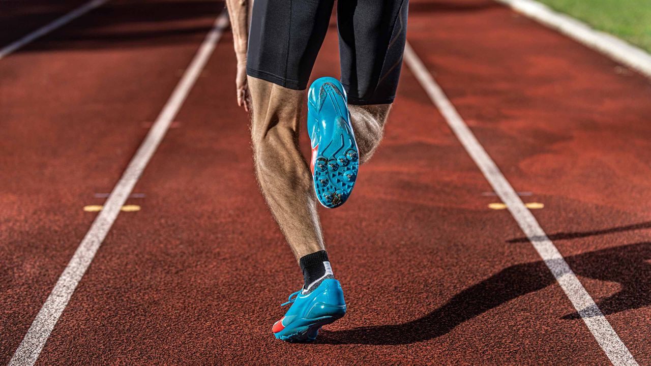 A man runs in his lane on a track.