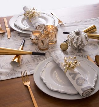 Christmas table runner with gold and white tableware and accessories