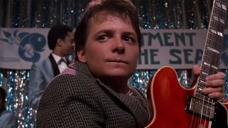 A close up of Michael J. Fox holding the red guitar in Back to the Future
