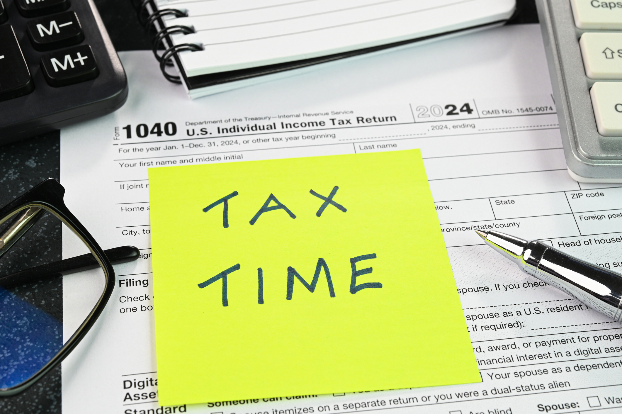 Concept of tax filing. Tax Time text on a yellow sticky note.