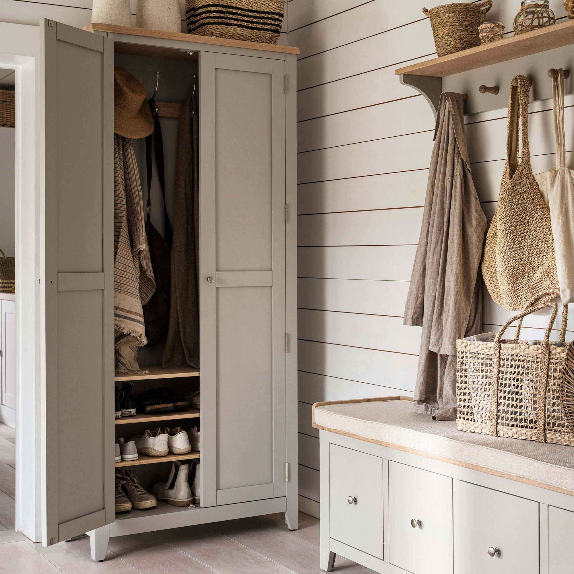 Grey storage cupboard with hooks, shoe shelves and a grey storage bench with hooks over the top