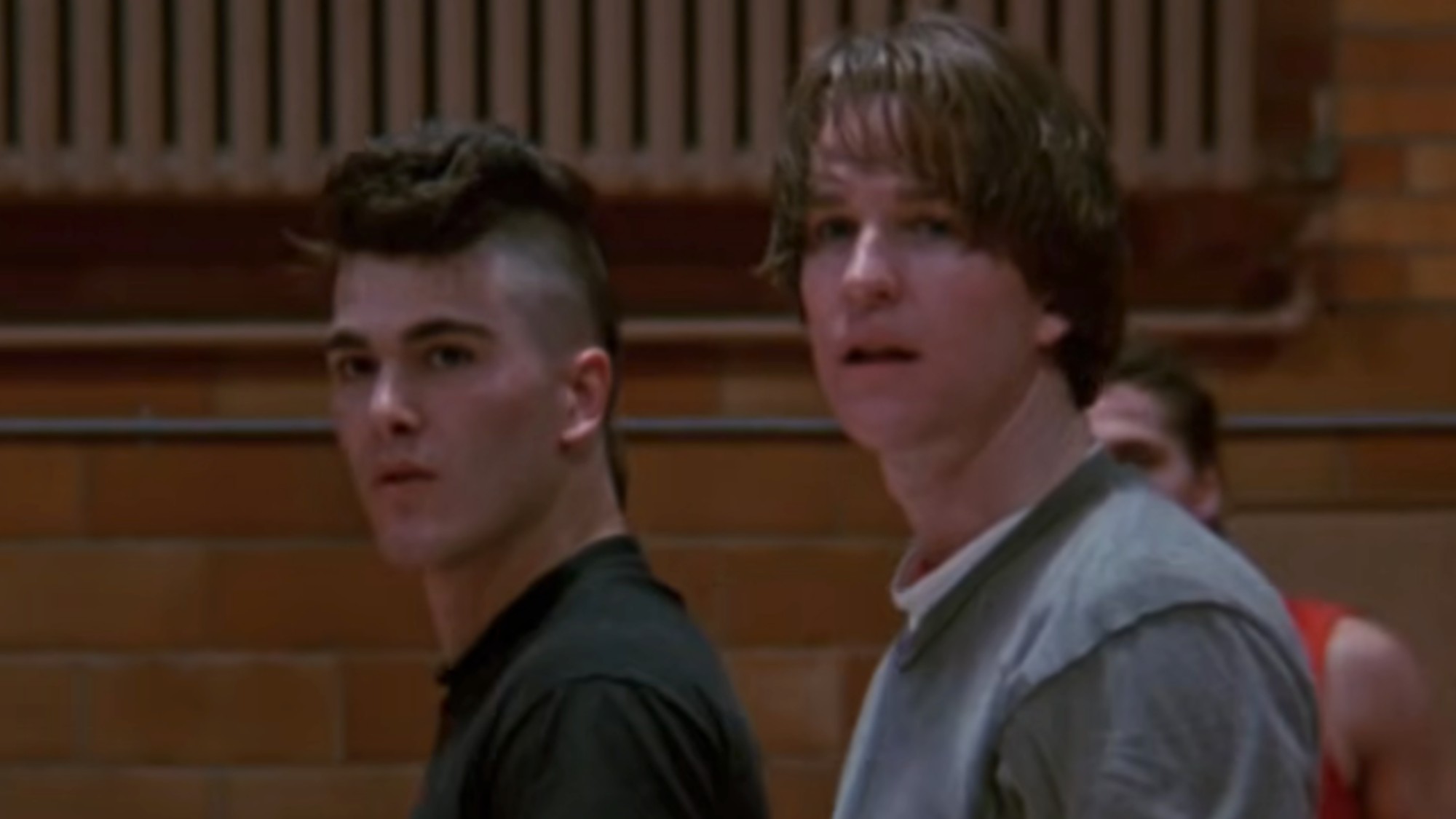 Michael Schoeffling on the left with a mohawk, standing with a sweaty Matthew Modine in Vision Quest.