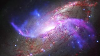 A spiral galaxy with purple and red streaks