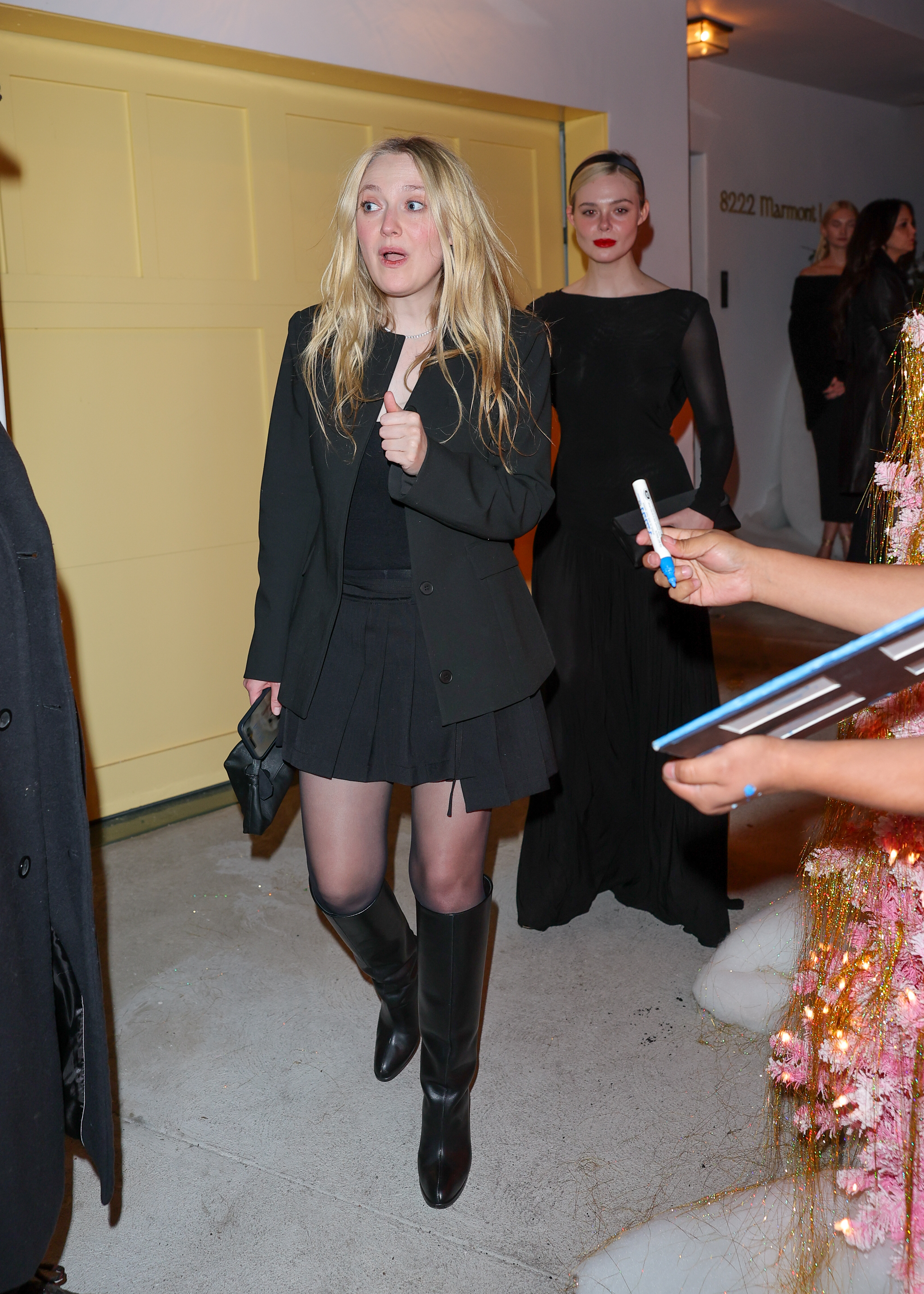 Elle and Dakota Fanning were spotted in two all-black holiday party looks in West Hollywood