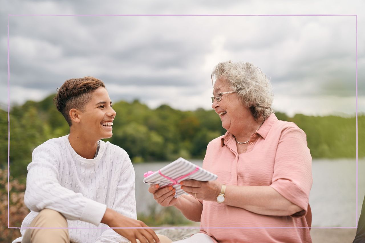 A grandmother and teenage boy laughing together while sitting outside