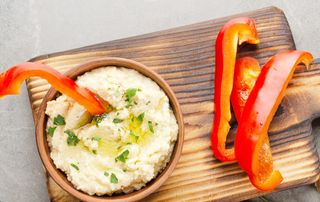 A bowl of hummus with red pepper