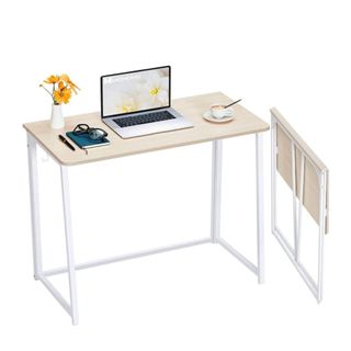 A white foldable desk with a laptop on it
