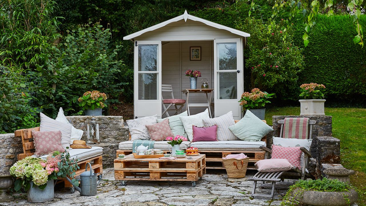 Pallet garden furniture in front of a summerhouse