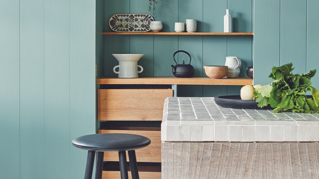 Kitchen with blue panelled built-in cabinets and island