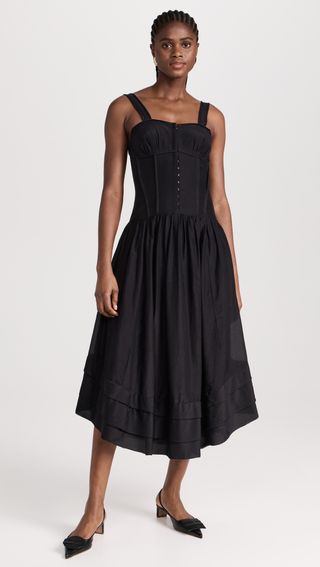 a model wears a black sleeveless midi dress