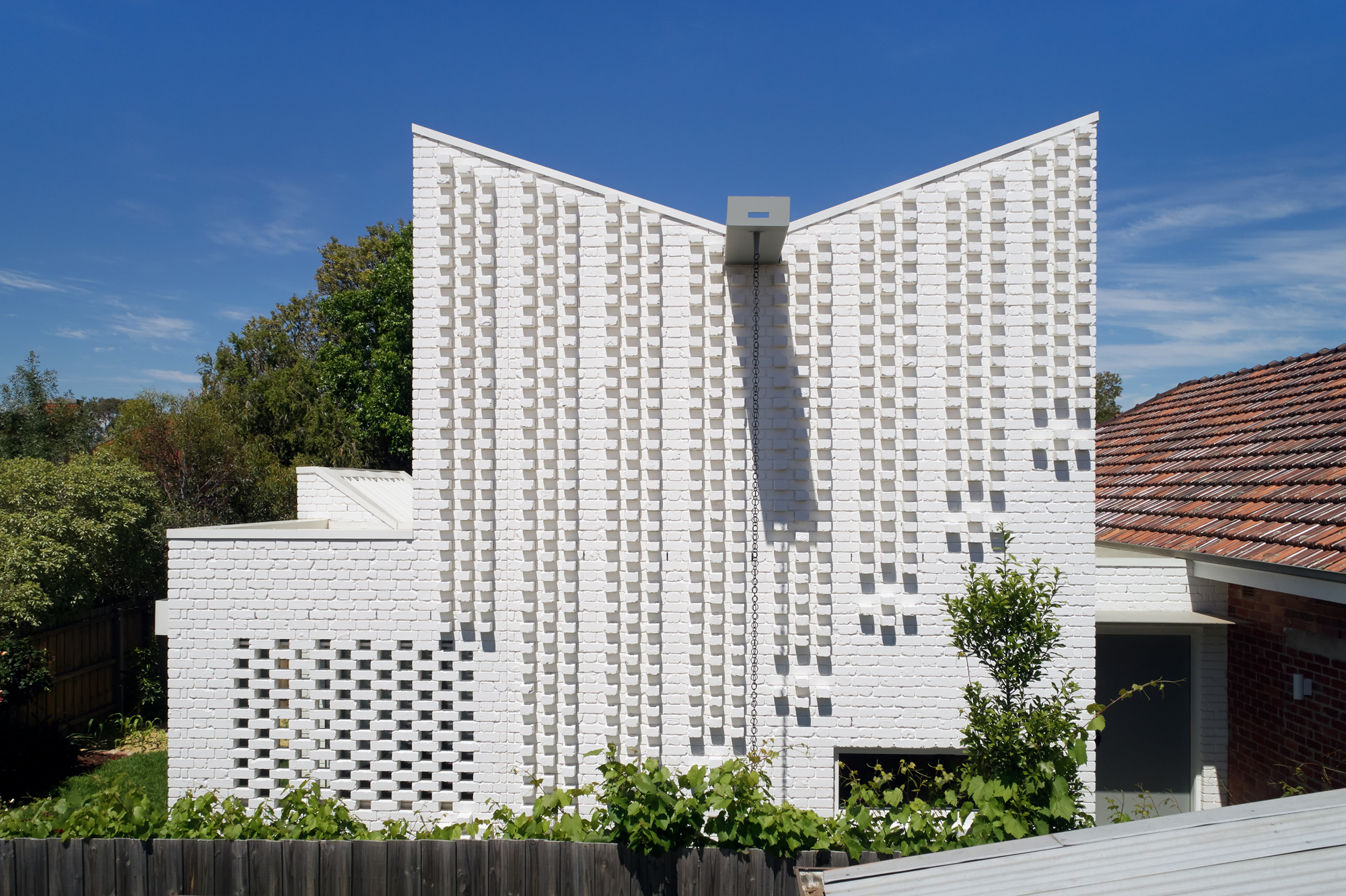 a white modern architecture building with a rain chain