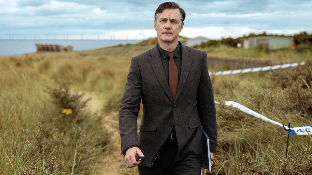 David Morrissey walking in a field by the sea in a scene from Sherwood season two.