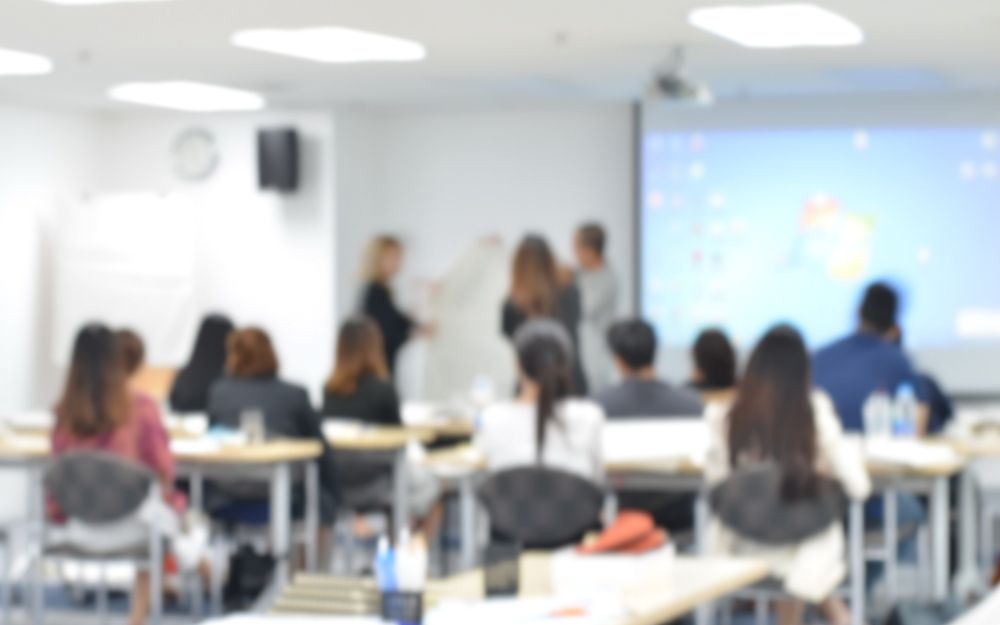 A group of people seated at desks during a training session