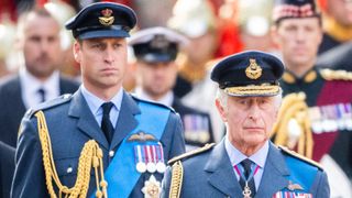King Charles III and Prince William, Prince of Wales walk behind Queen Elizabeth II's coffin
