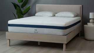 Best hybrid mattress: image shows the Helix Midnight mattress on a wooden bedframe, set against a dark wall