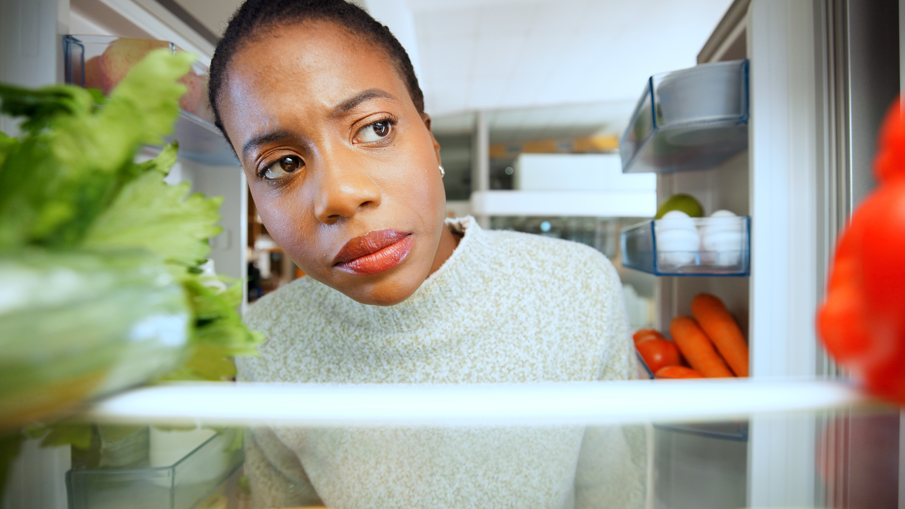 Woman looking inside fridge