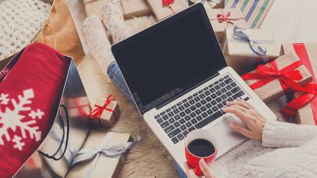 Christmas gift cards: Christmas shopping on laptop with presents around