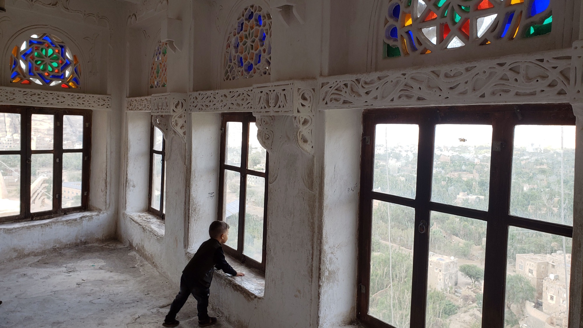 A boy wanders in a room with multicolored stained-glass windows inside the tourist site of the Dar al-Hajar (Rock Palace), on the outskirts of Sana'a, Yemen.