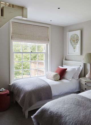 Wooden twin beds with fluffy grey blankets
