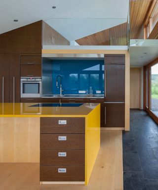 brown, yellow and blue kitchen, cork units, granite floor, blue backsplash, yellow countertop on island