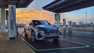 Audi etron Sportback being recharged at an electric forecourt at dusk