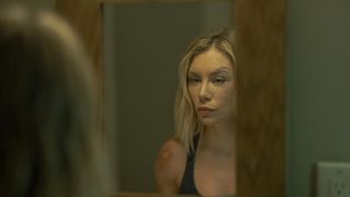 Harcourt (Jennifer Holland) looking in the mirror in Peacemaker season 2