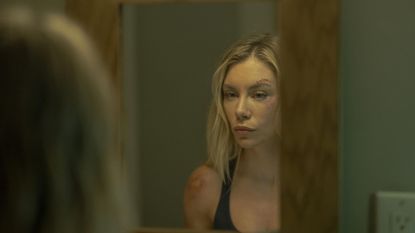 Harcourt (Jennifer Holland) looking in the mirror in Peacemaker season 2