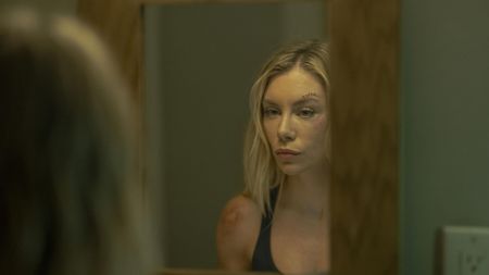 Harcourt (Jennifer Holland) looking in the mirror in Peacemaker season 2