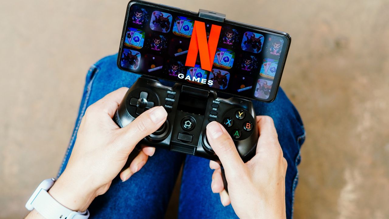 a person playing on a joystick and the Netflix Games logo displayed on a smartphone screen