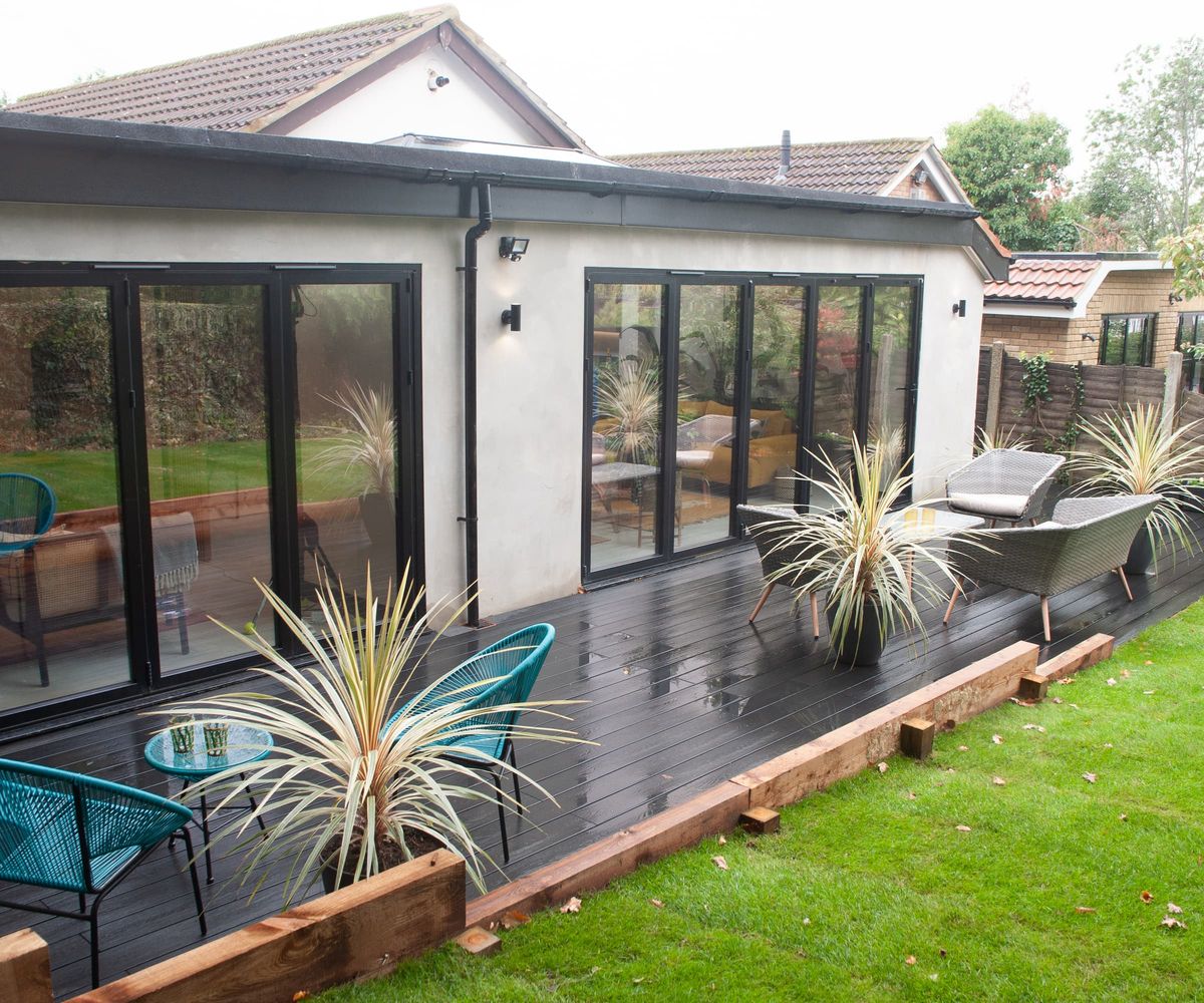 Black decking outside an extension with bifold doors