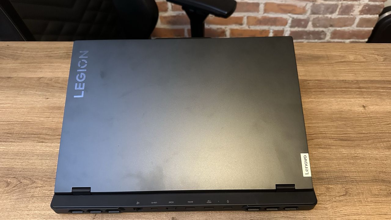The Lenovo Legion Pro 7i (Gen 9) with lid closed on a wood desk