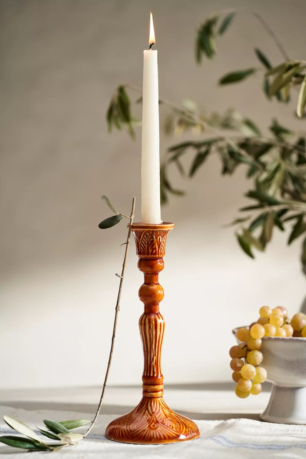 Deep orange enamel candle holder with white taper candle