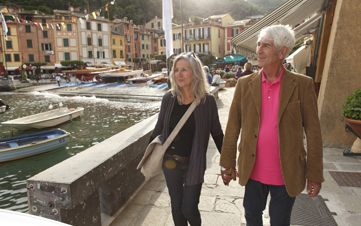 Senior couple walking by the water, Italy