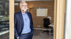 An older businessman looks out the window.