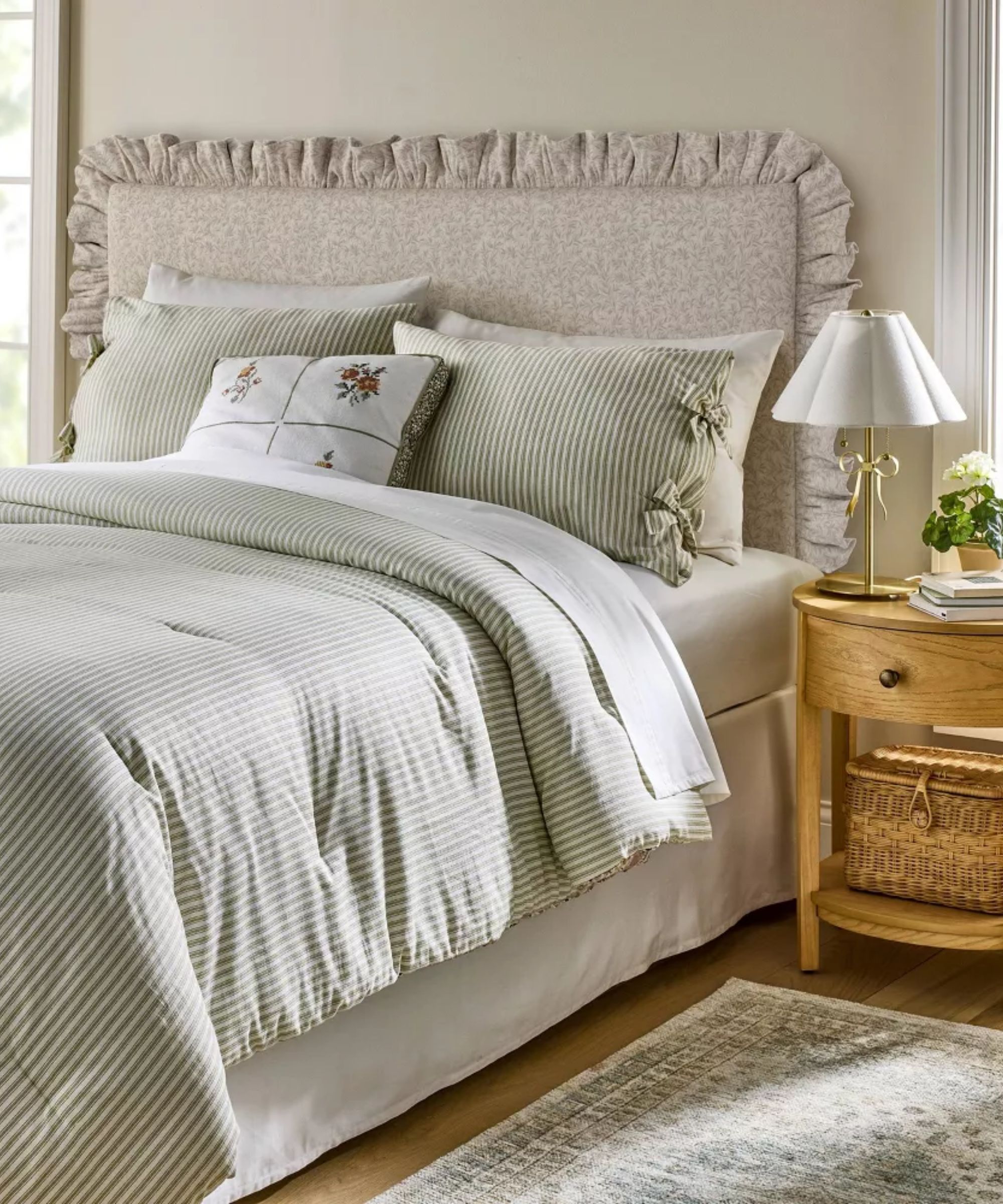 teenage bedroom styled by shea mcgee for target with a floral ruffled headboard and striped bed linen