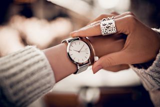woman looking at time on wristwatch
