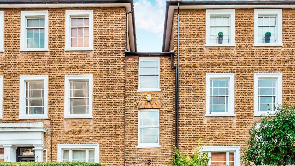 house with brick wall and trees