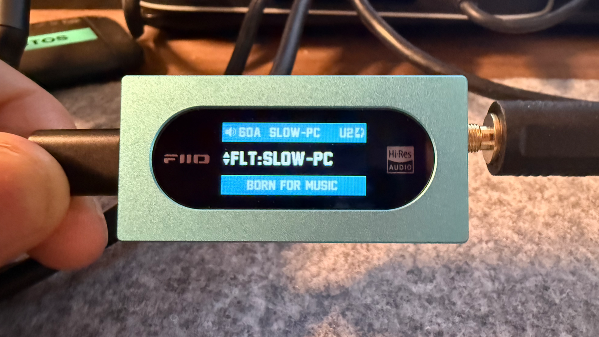 FiiO KA15 portable DAC photographed from the front to show the user interface