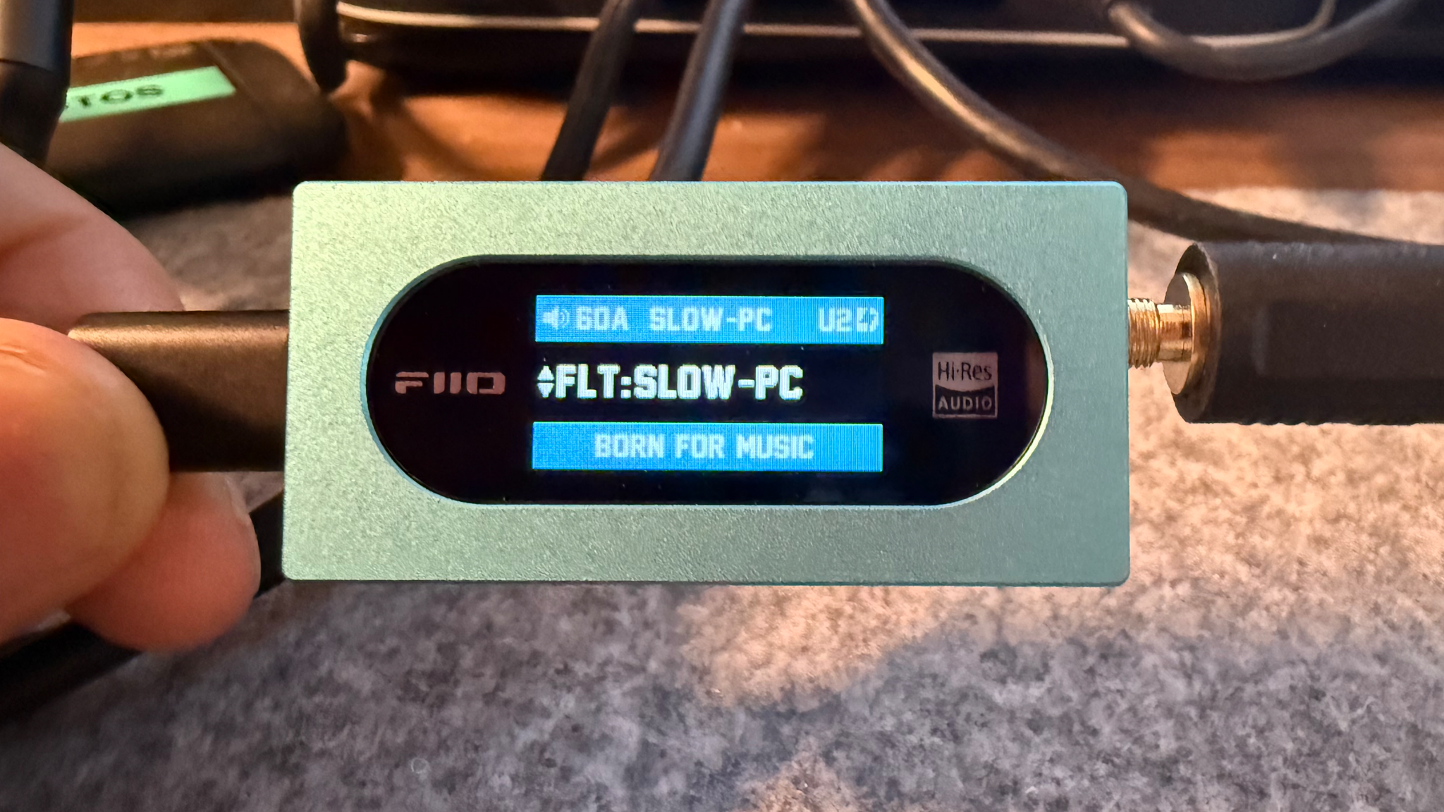 Портативный ЦАП FiiO KA15, фотография спереди, демонстрирующая пользовательский интерфейс.